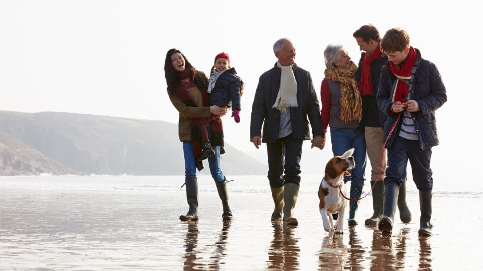 Multi-generational family walking on beach